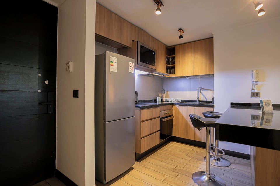 Sleek and modern kitchen perfect for cooking up a storm, complete with all essential appliances and cozy bar seating.