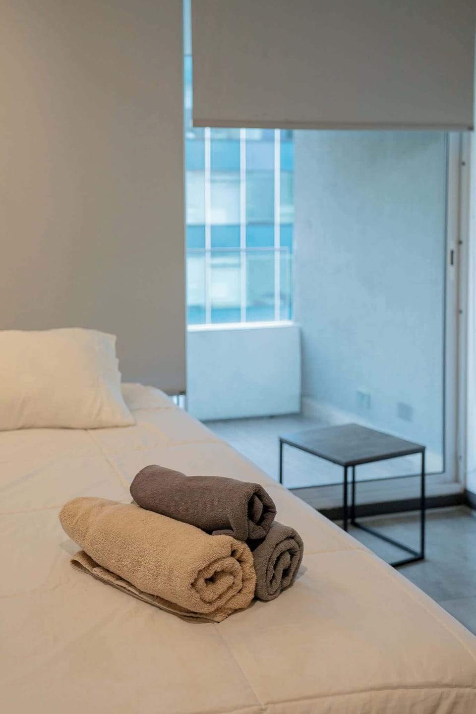 Relax in this cozy bedroom with a modern touch and a view of the city skyline.