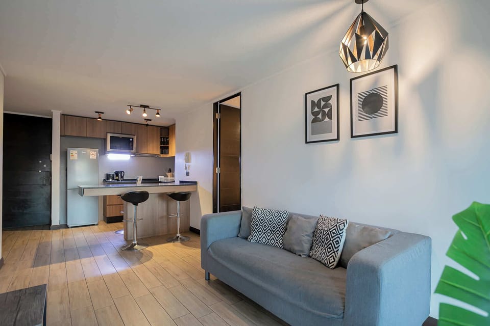 Experience modern comfort in this stylish living area with an open kitchen, perfect for relaxing after exploring the city.
