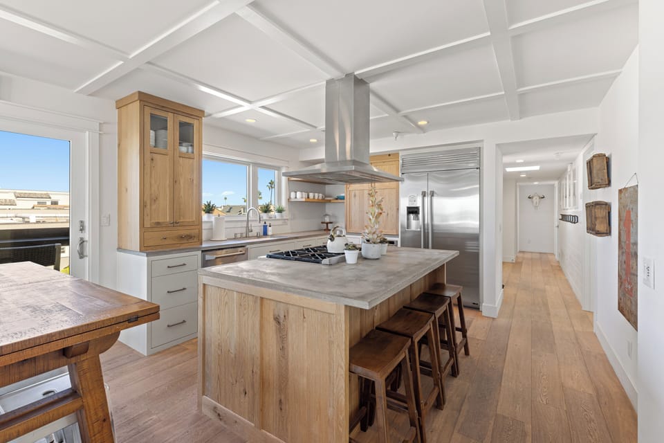 Newly Remodeled featuring high-end Appliances, sleek countertops, and a central Island with an integrated Stove, this open-plan modern Kitchen is both stylish and functional, with ample seating for casual Dining.