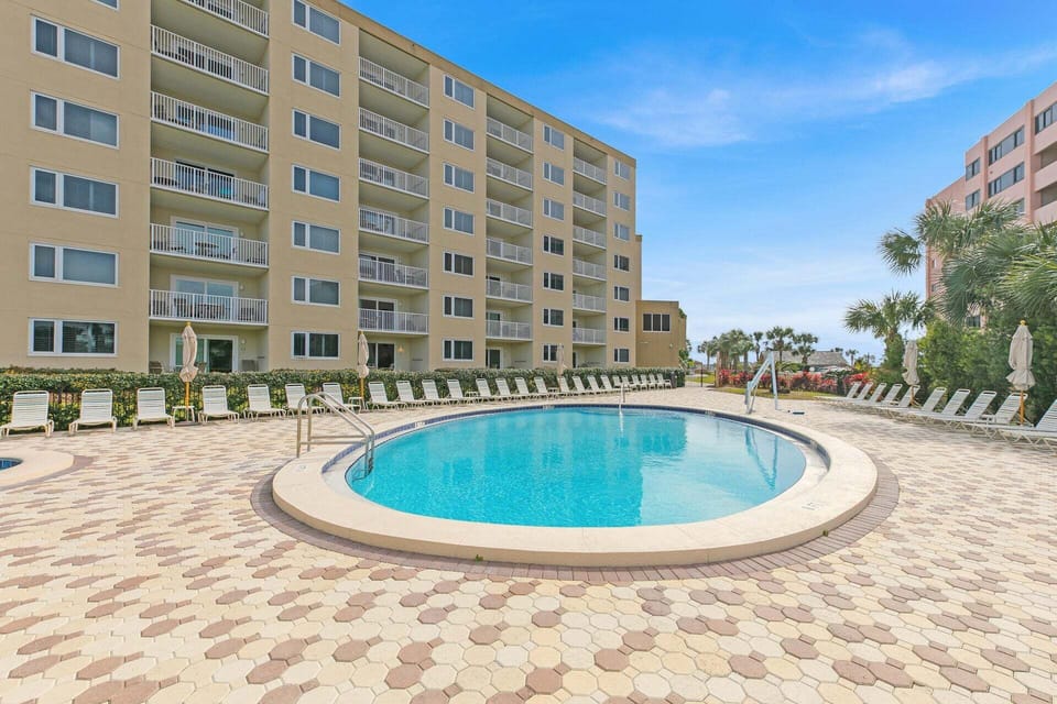 Sparkling Islander Beach Resort pool surrounded by comfortable loungers where you can soak up the sun on beautiful brick-paved deck.