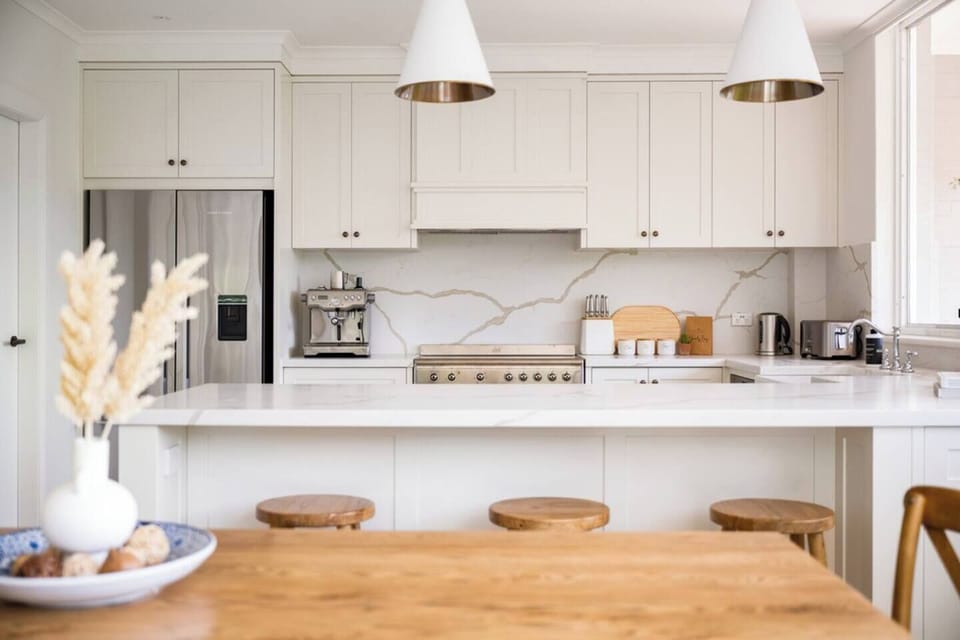 The kitchen is the heart of the home, detailed with elegant tapware, marble-style benchtops and splashbacks, statement lighting and modern appliances.
