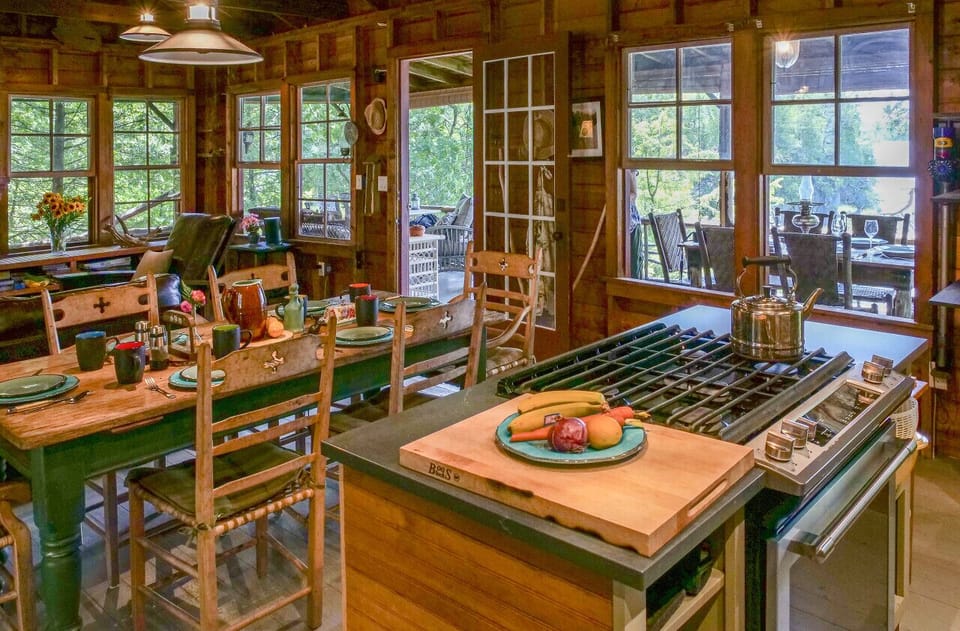 The great room, vantage from the kitchen with open living to the screen porch, living and dining room