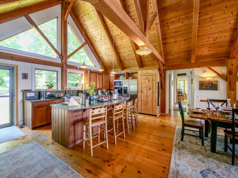The Great Room with solid structural fir posts and 20` ceilings enjoys open kitchen to dining room, wood stove, and contiguous to screen porch