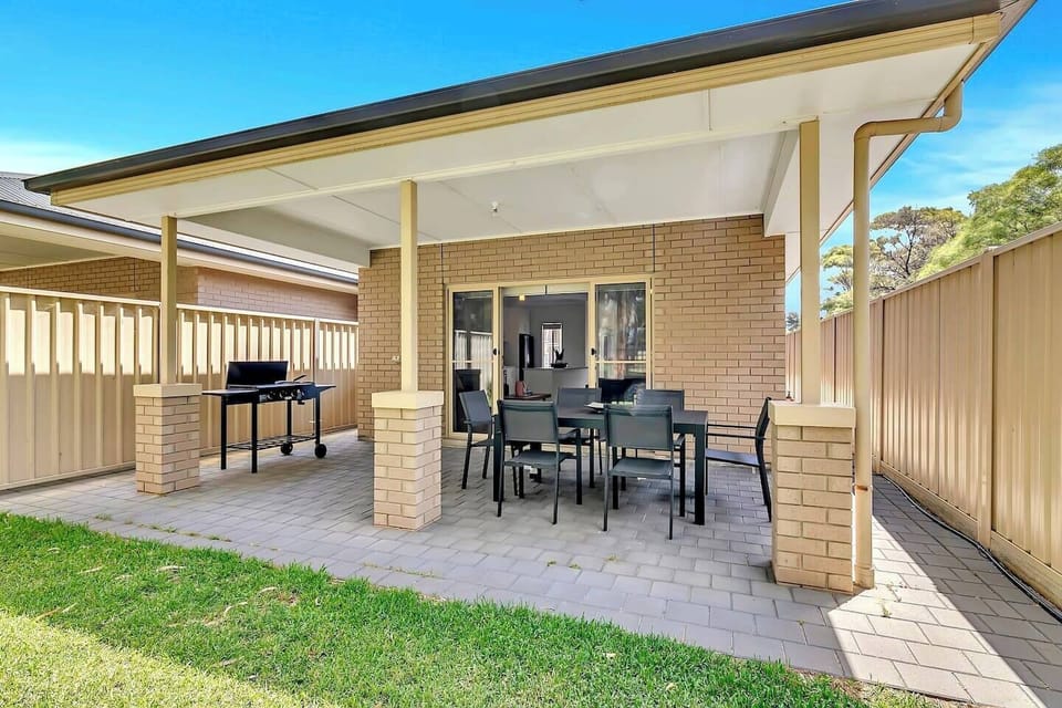 A patio area complete with a BBQ and a six-seater table provides a laidback setting to dine alfresco while overlooking the backyard. 
