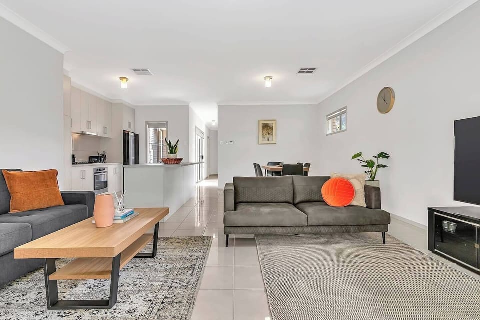 Relax in the light-filled living area, where two sofas offer cosy seating to kick back with a movie while central air-conditioning and heating ensure year-round comfort. 
