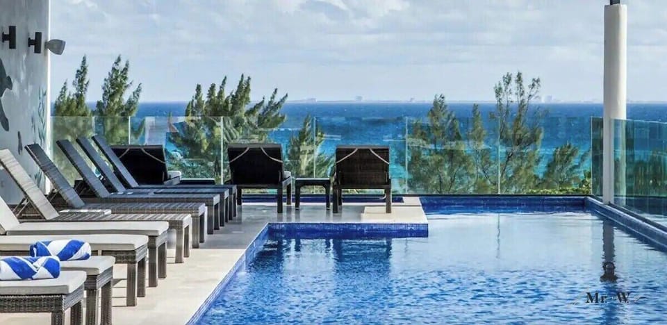 Lounge poolside with panoramic ocean vistas.