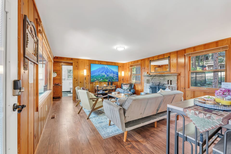 Main Living room with comfortable seating, full fireplace, and large smart TV.