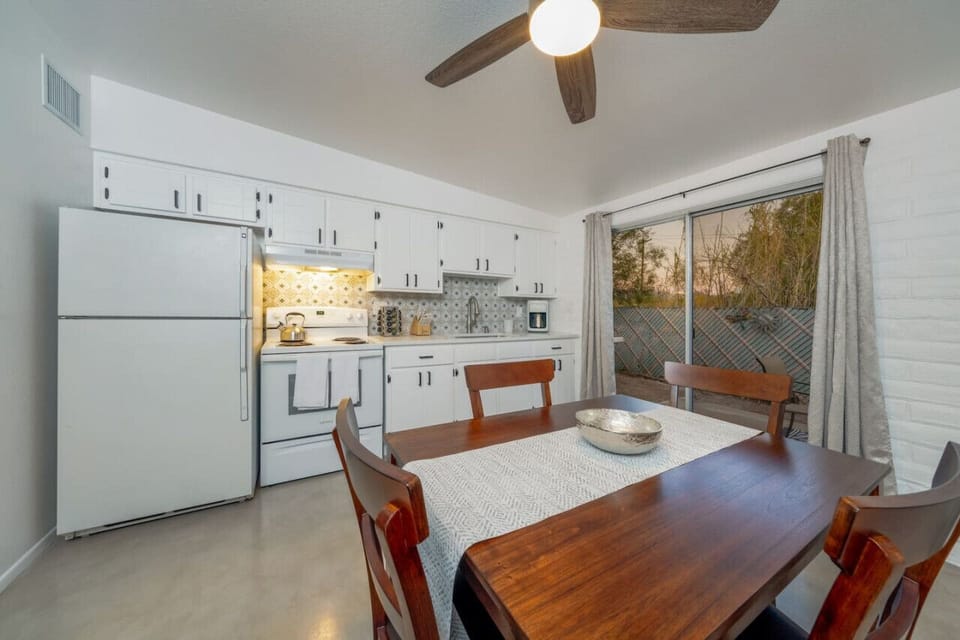 Dining area with table to seat four, and smaller but mighty, remodeled, bright, and functional kitchen with access to outdoor patio