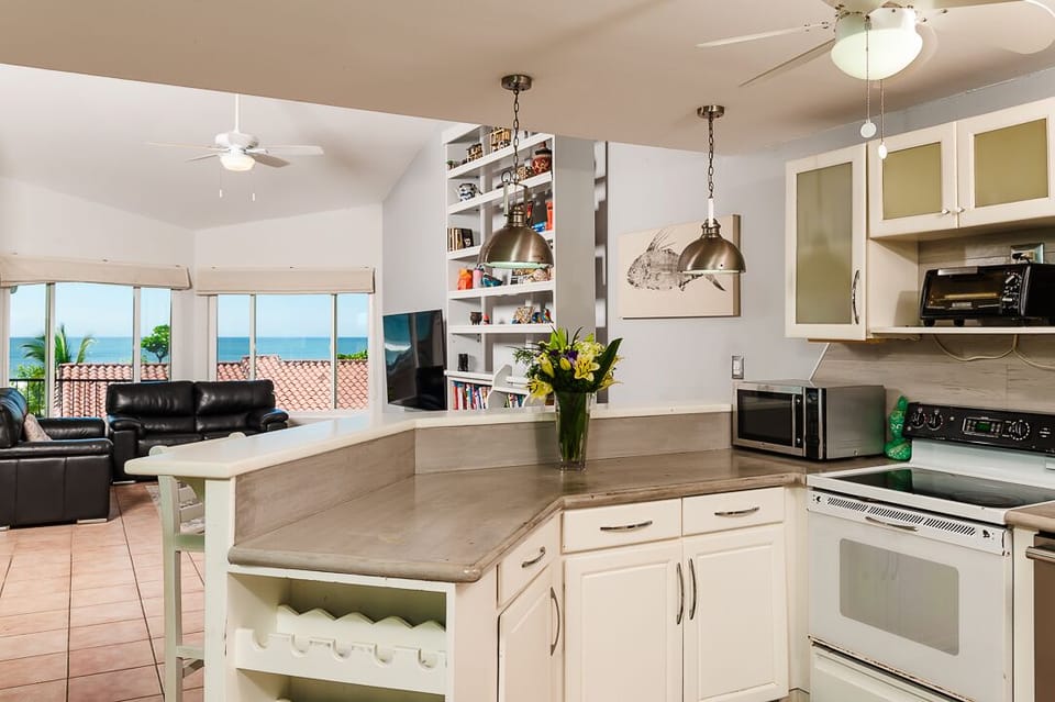 Cook and dine in style in the kitchen with beautiful, functional furniture, designed for comfort and convenience during your family vacation in Tamarindo, Costa Rica.