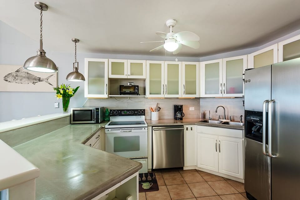 Prepare full family meals in the fully equipped kitchen of this Tamarindo condo, featuring modern appliances, granite countertops, and everything you need for a stress-free vacation.