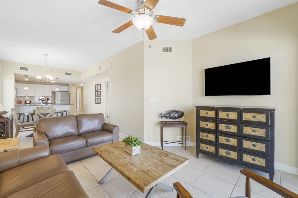 Spacious living area with leather seating and a mounted flat-screen tv