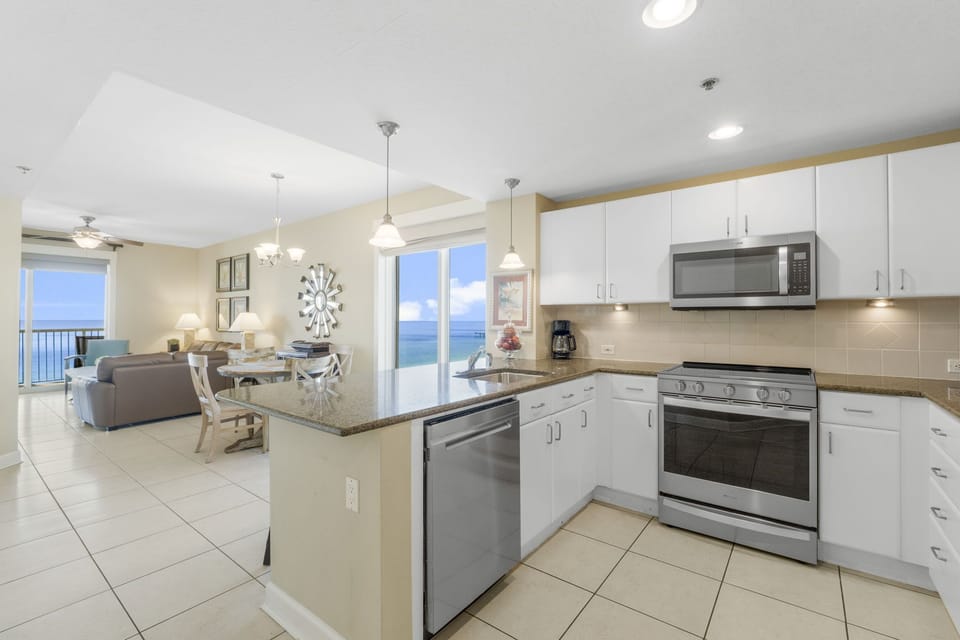 Modern kitchen with stainless steel appliances and ocean views from the adjacent living area