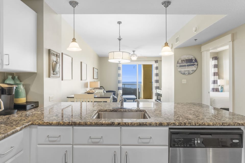 Modern kitchen with granite countertops and ocean view from the dining area.