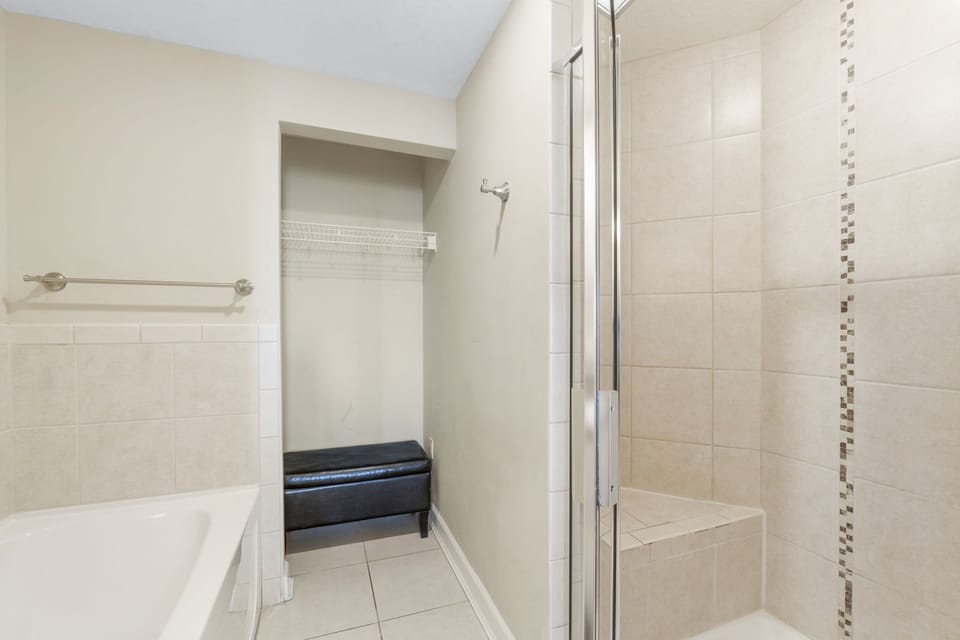 Modern bathroom featuring a tiled walk-in shower with built-in bench.