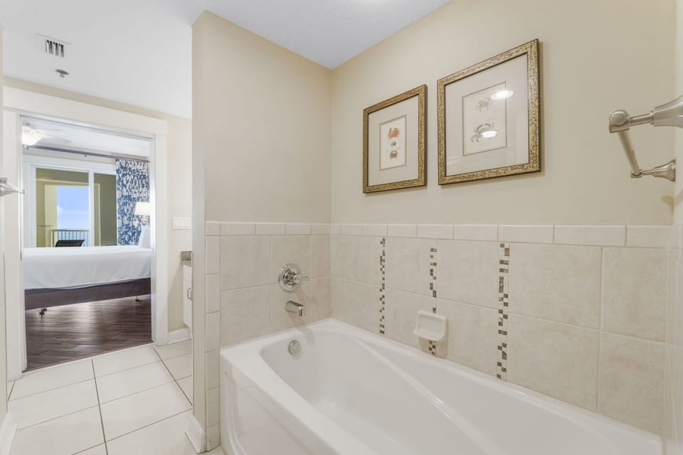 Relax in the tiled bathtub adjacent to the bedroom in this modern bathroom.