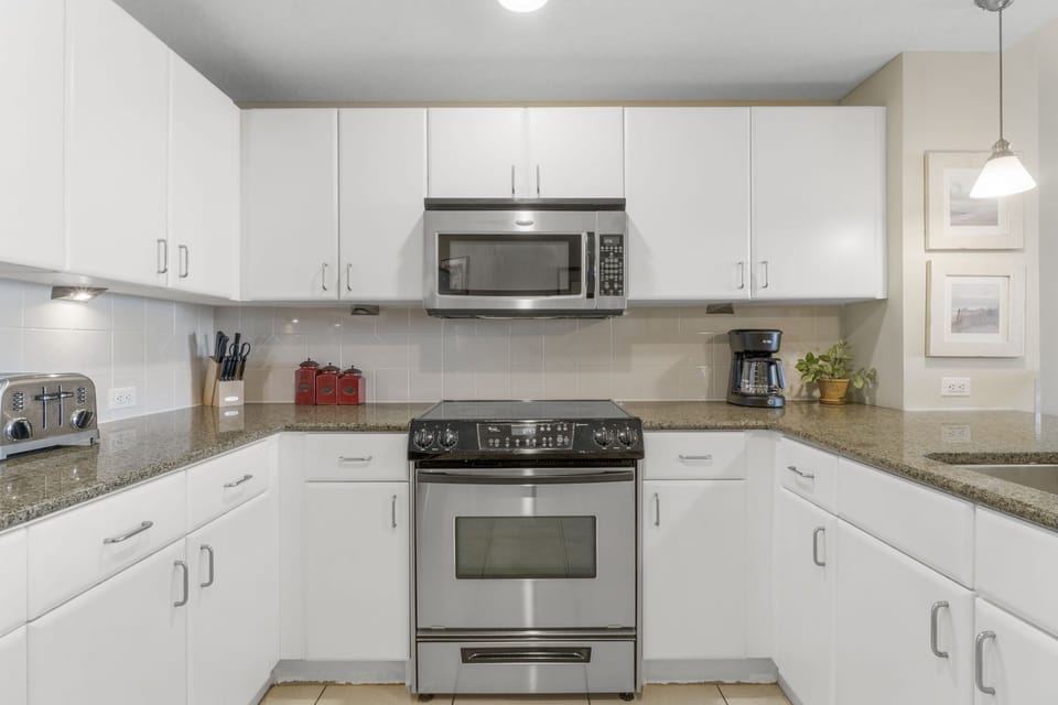 Modern kitchen with stainless steel appliances and ample white cabinetry