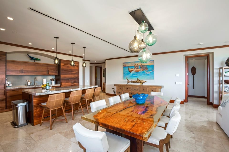 Rustic wood and modern polish collide at the dining table, where surfboard art nods approvingly from the wall   