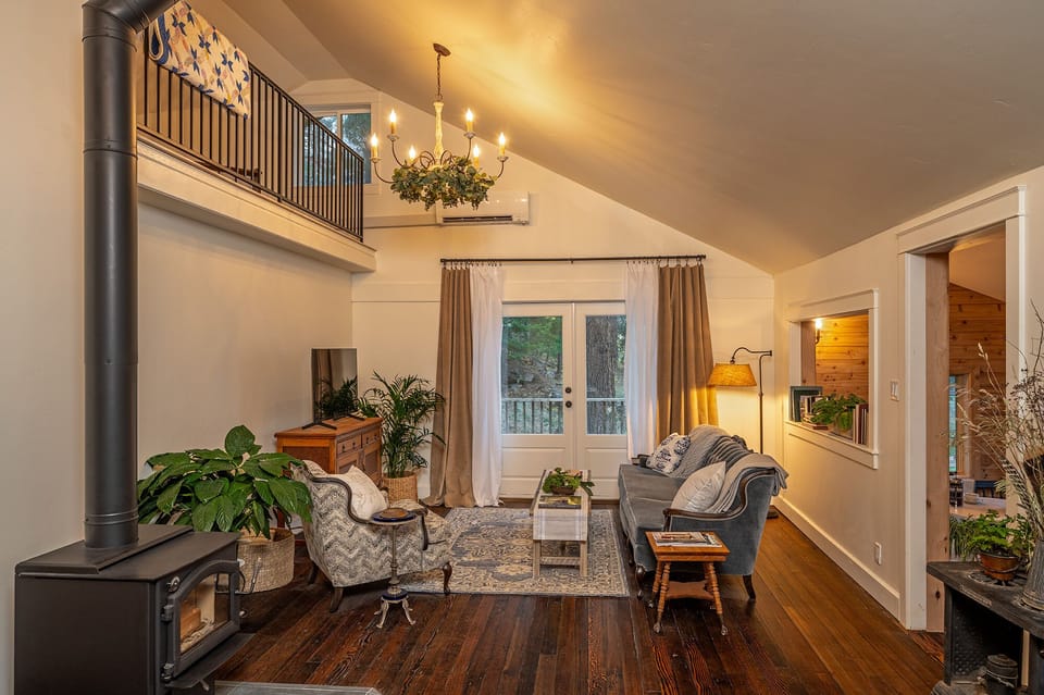 Living room with comfortable seating, smart TV, and cozy wood stove.