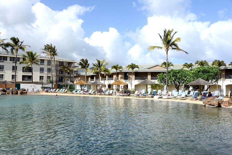 Pool area. It's surrounded by sand for a beach vibe.