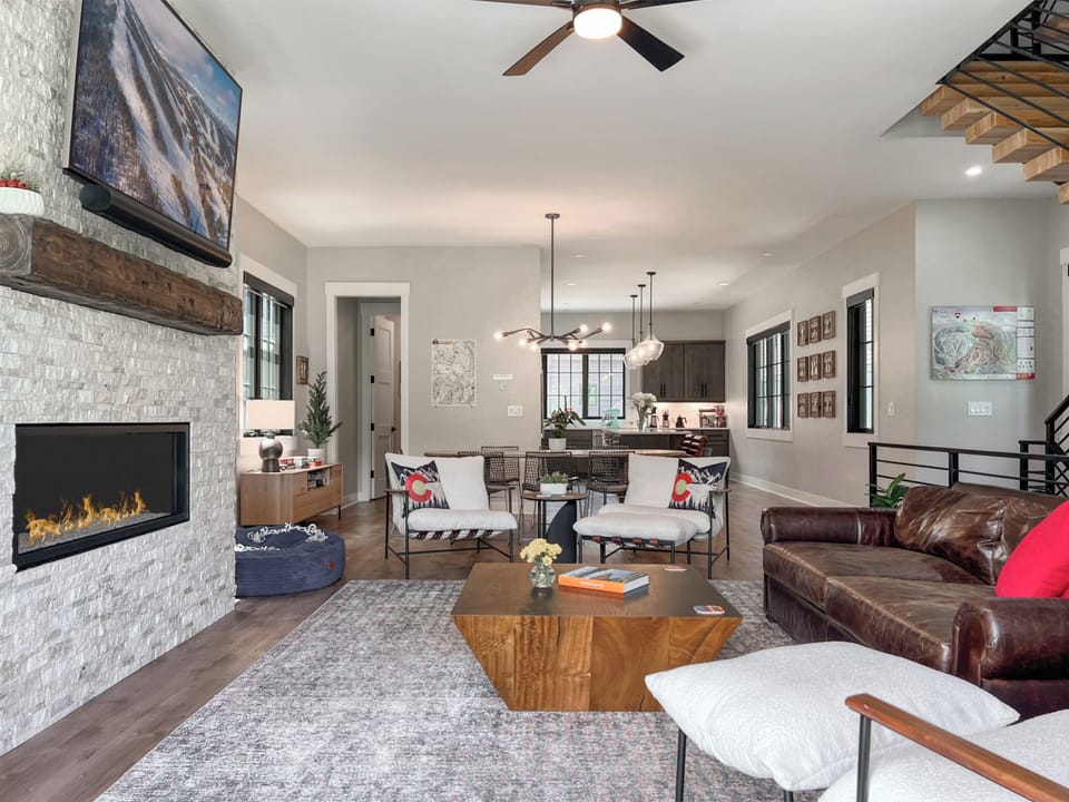 - Gather together in this open concept space where every detail is thoughtfully styled - Large dining table, fireplace lounge, and airy windows bring light and comfort - Ideal for movie nights, dinners in, and unforgettable mountain memories