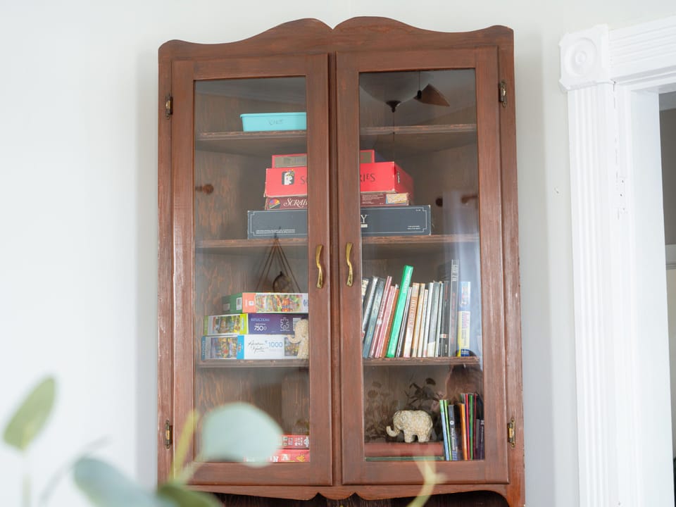 Cupboard full of games, puzzles, books, and kids' toys. 
