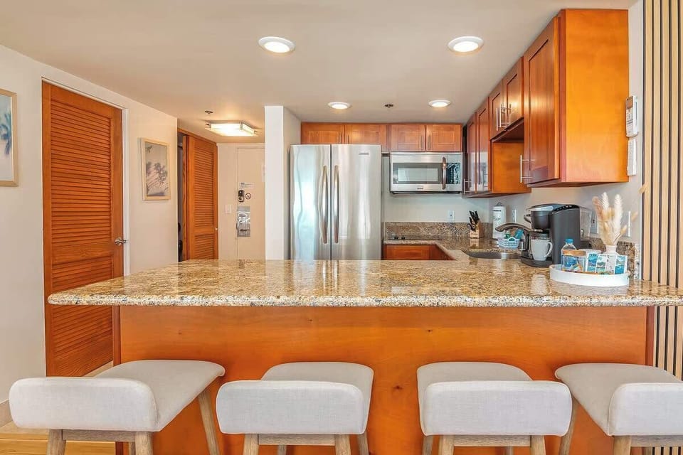 Fully equipped kitchen with countertop and 4 bar stools.