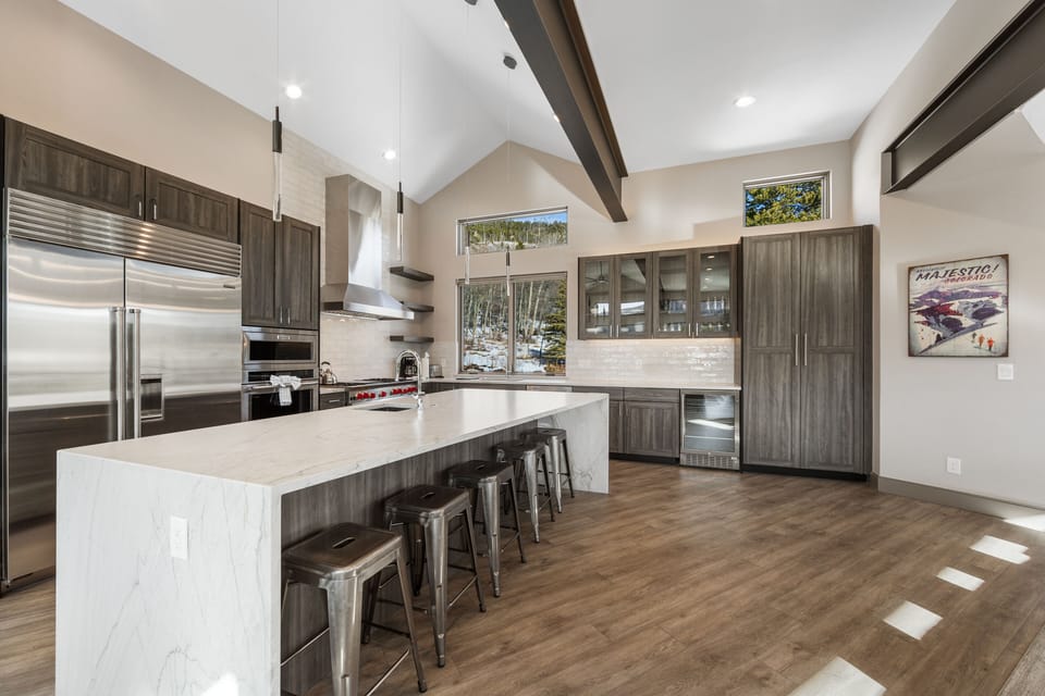 Chef's kitchen with quartz countertops and a breakfast bar with seating for 5.