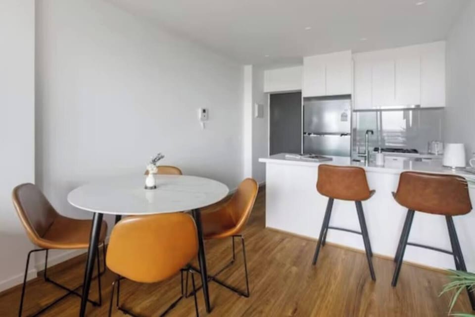 The open-plan dining area features a chic, round marble-look table for four. 