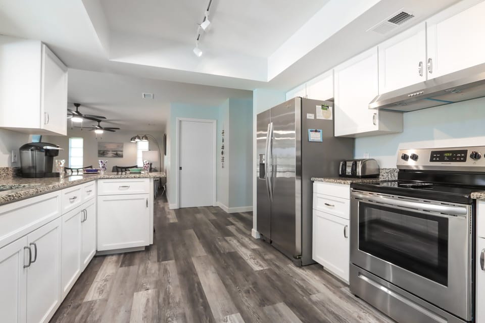 Newly renovated kitchen featuring sleek white cabinetry and stainless steel appliances