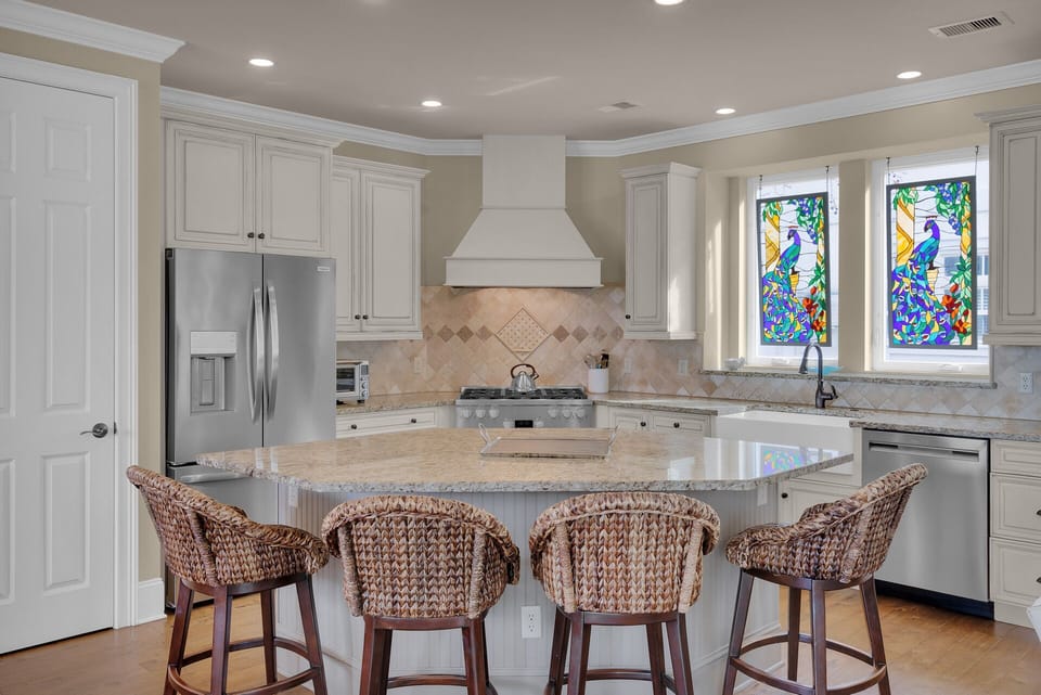 Fully stocked kitchen with stainless steel appliances and 4 barstools for extra seating.