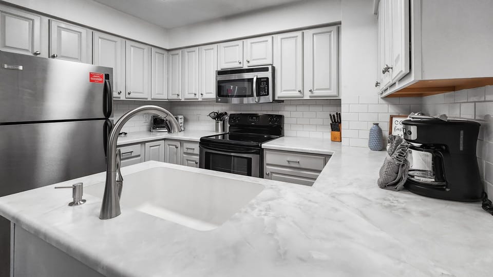 Kitchen: Well-equipped kitchen, stainless steel appliances, white counter and cabinets, range of basic cookware
