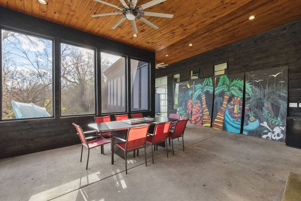 Massive patio space featuring a dining table with seating for 8, custom artwork, fireplace, views of the pool, and wrap-around access to the hot tub.