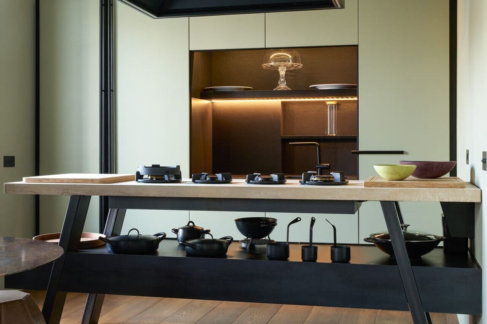 Elegant open-concept kitchen featuring a sleek central island, modern appliances, and a blend of warm wood and metal elements.