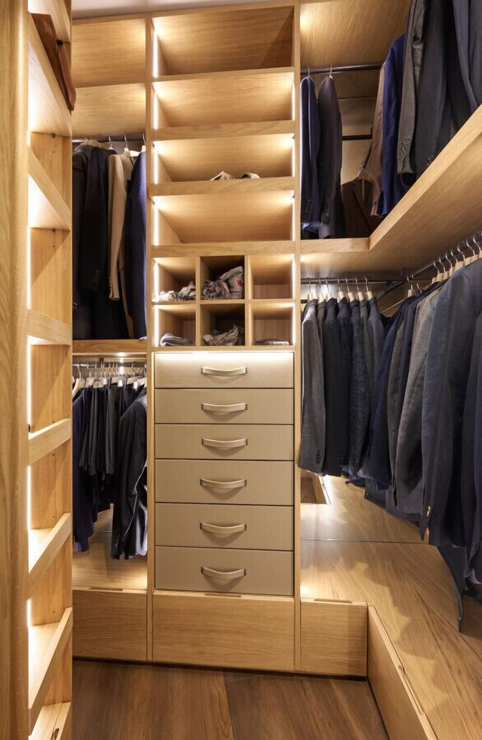 Custom walk-in closet with integrated lighting, tailored compartments for suits, shirts, and accessories, and elegant wood finishes.