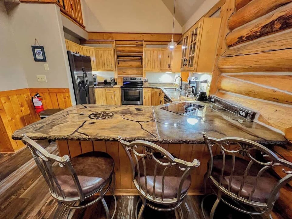 The kitchen features custom counter tops, mountain views, plenty of dinnerware for your whole group, and modern appliances