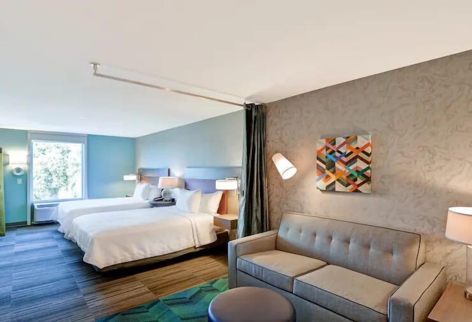 Relax together with cozy sofa seating beside crisp, inviting beds.