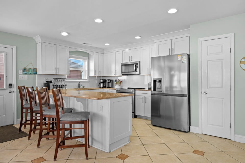 Your fully equipped kitchen awaits with granite counters, stainless appliances, and a breakfast island where you can start each morning with coffee.