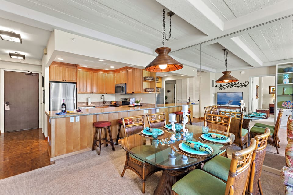 Bright and inviting open-concept kitchen featuring warm wood cabinetry, sleek granite countertops, and a spacious island that flows seamlessly into the living and dining areas. Perfect for entertaining or relaxing in comfort.