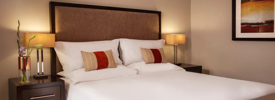 Sink into crisp linens and unwind under warm bedside glow.