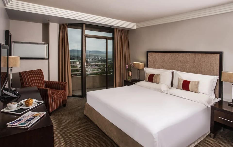 Wake to balcony views and sunlight spilling across the bed.