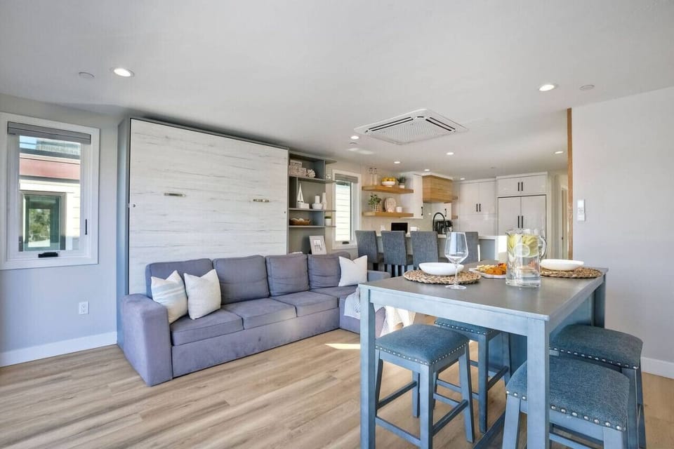 DINING AREA Bright open-concept dining space with table seating for four and additional kitchen bar seating, perfect for family meals, group dinners, and morning coffee in this Mission Beach San Diego vacation rental near the beach and boardwalk.