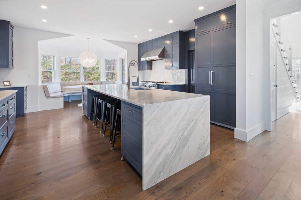 Subzero refrigerator and a large island with gorgeous waterfall countertops