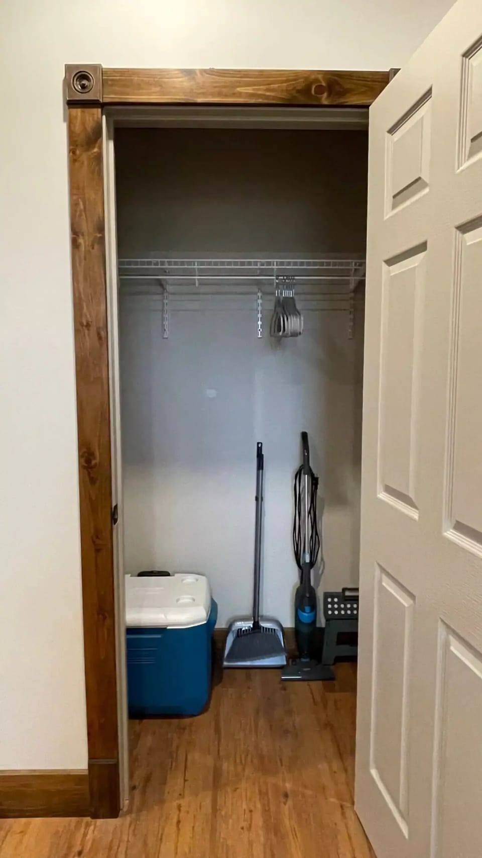 Coat closet with hangers, cooler, cleaning supplies and step stool 