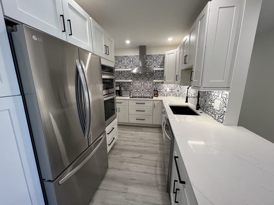 Fully equipped kitchen including huge French-door fridge, microwave, dishwasher.