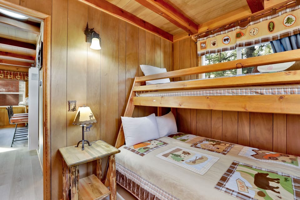 Peaceful cabin bedroom with plush bedding, and beautiful views—ideal for restful nights, cozy mornings, and a relaxing mountain escape.