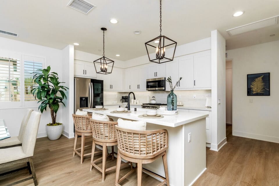 Bright kitchen w/ island seating, pendant lighting & stainless appliances