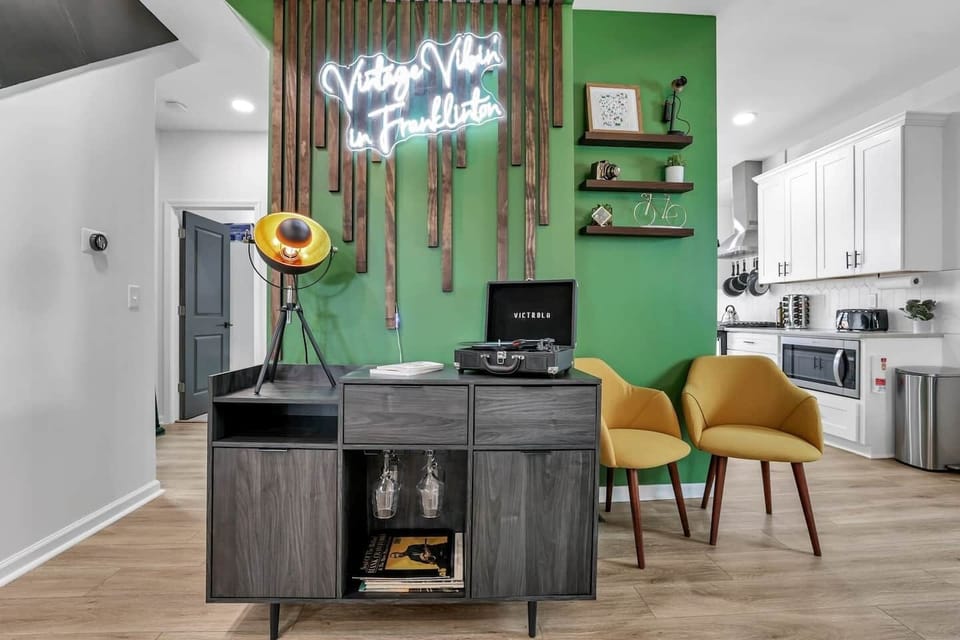 Our beautiful accent wall featuring vintage style record player. Wine glasses, board games, records and kids coloring books are also found in the cabinet. 