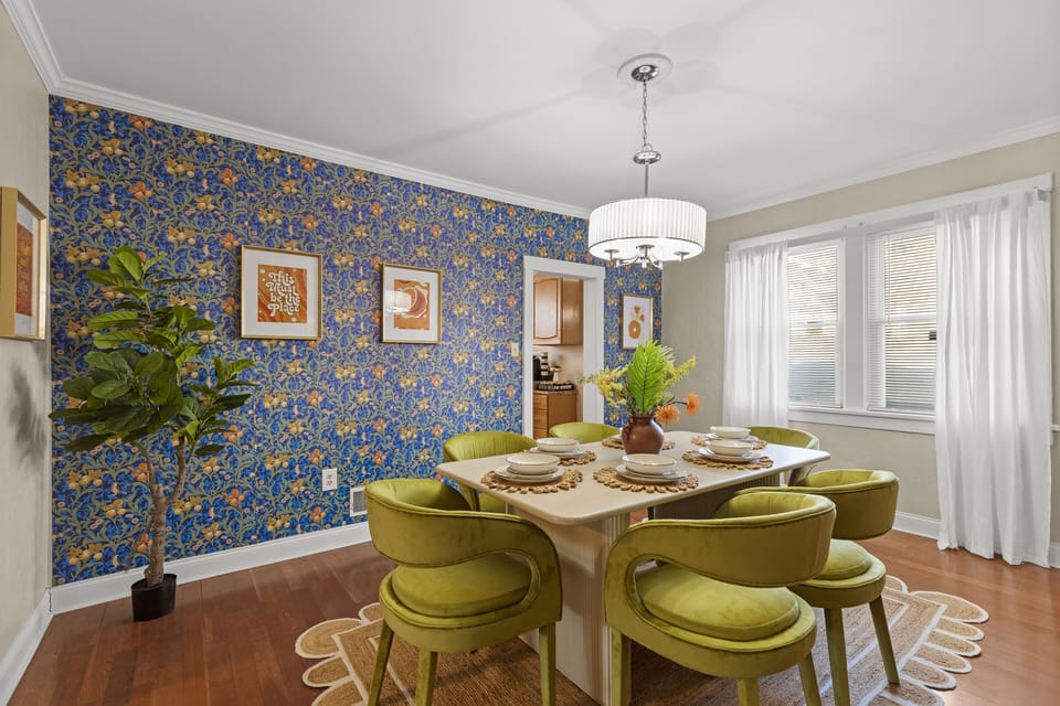 Dining area with indoor plant, and windows with sheer curtains