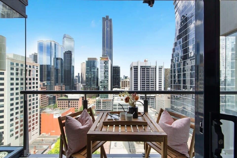 A balcony with a setting & city views.